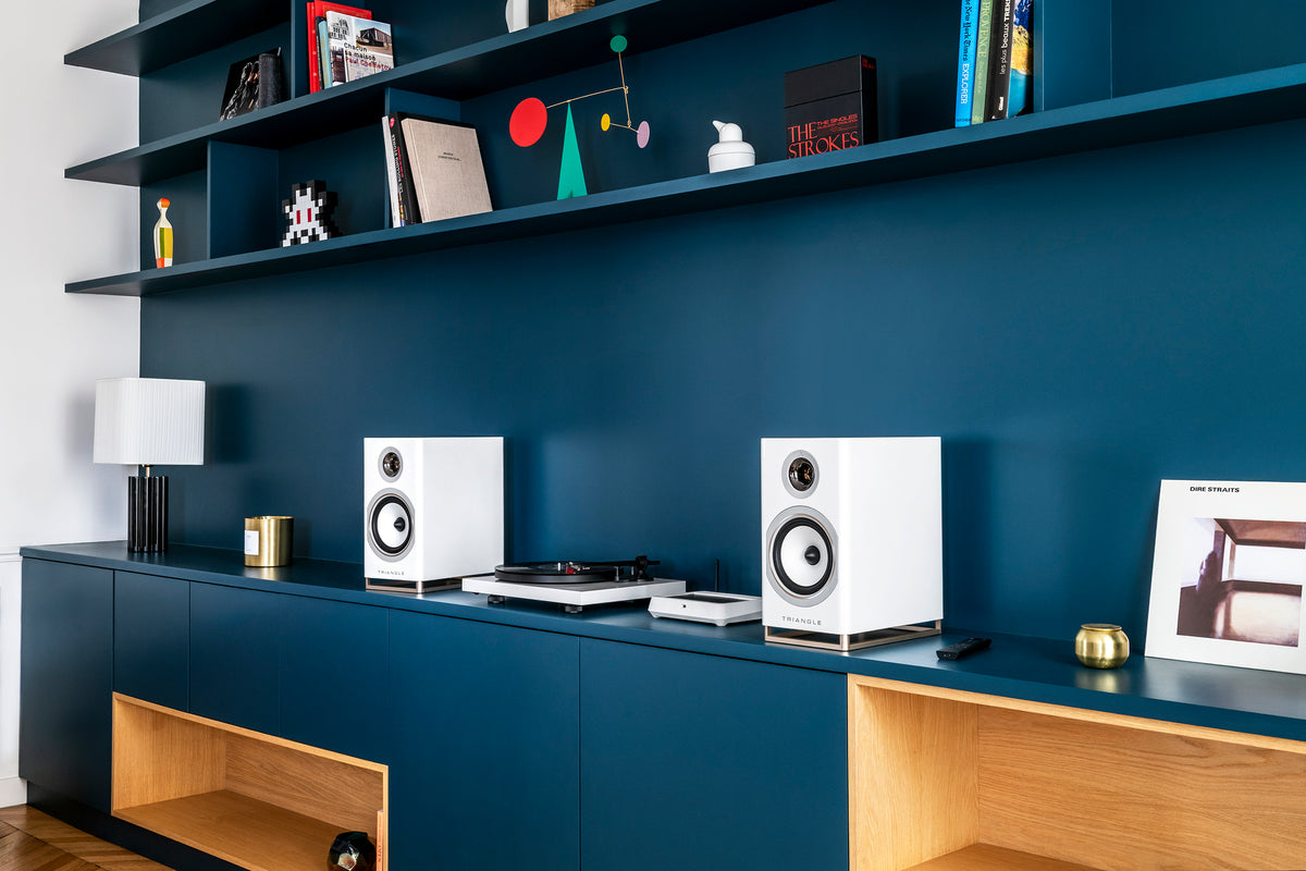 Blue Capella speakers and a turntable on a console table